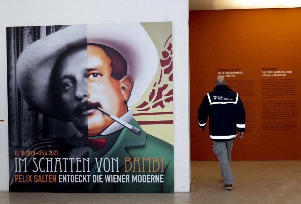 Un hombre pasa junto a un póster de Felix Salten (izquierda) al entrar en la exposición "Más allá de Bambi - Felix Salten y el descubrimiento del modernismo vienés" en el Museo de Viena el 23 de marzo de 2021.  Foto de Joe Klamar / AFP