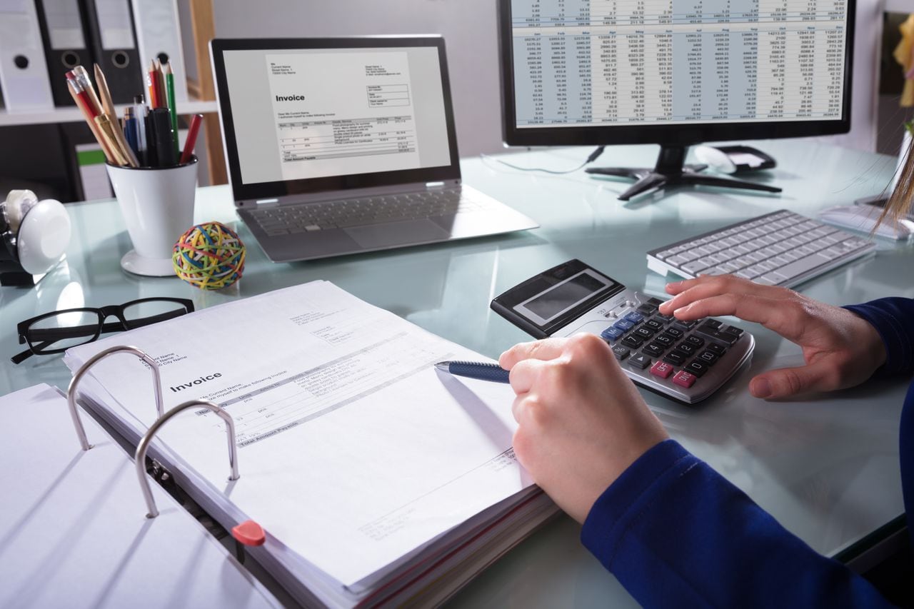 Close-up de la mano de un empresario calcular la factura en el lugar de trabajo
