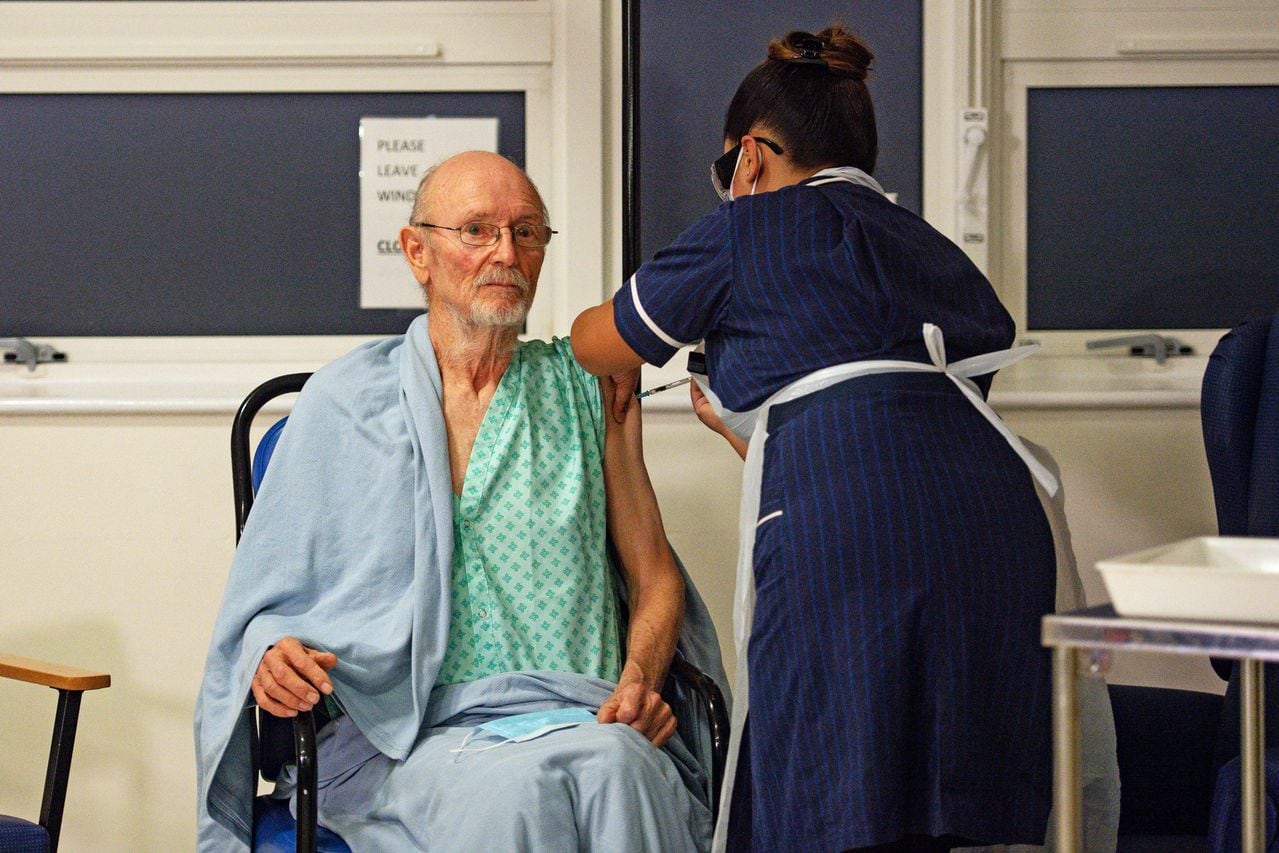 Una enfermera administra la vacuna Pfizer-BioNtech Covid-19 al paciente William "Bill" Shakespeare (izquierda), de 81 años, en el Hospital Universitario de Coventry, en el centro de Inglaterra, el 8 de diciembre de 2020. - Gran Bretaña el 8 de diciembre aclamó un punto de inflexión en el lucha contra la pandemia de coronavirus, ya que comienza el programa de vacunación más grande en la historia del país con un nuevo pinchazo de Covid-19. (Foto de Jacob King / POOL / AFP)