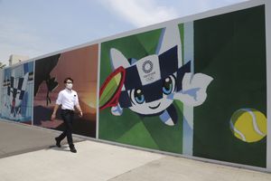 Un hombre camina frente a murales que promueven los Juegos Olímpicos, que están programados a iniciar en julio de 2021, el lunes 24 de mayo de 2021, en Tokio. (AP Foto/Koji Sasahara)