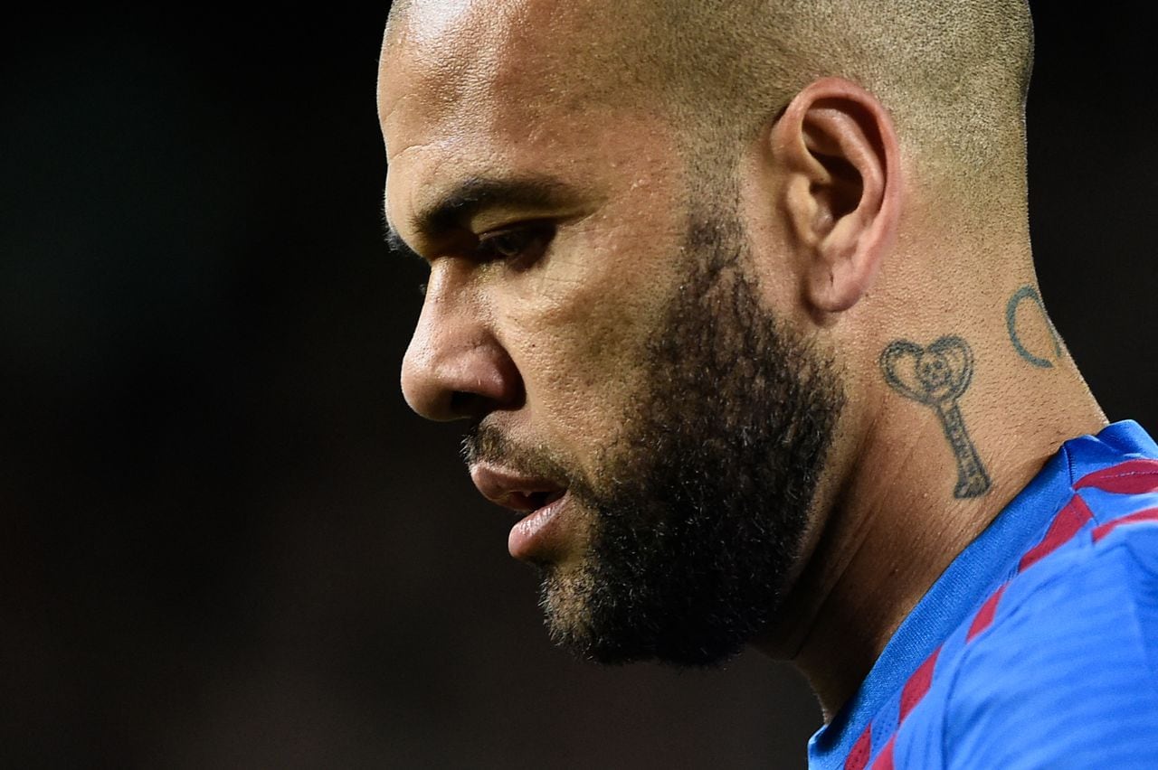 (FILES) In this file photo taken on March 13, 2022 Barcelona's Brazilian defender Dani Alves looks on during the Spanish league football match between FC Barcelona and CA Osasuna at the Camp Nou stadium in Barcelona. - Former Brazil defender Dani Alves was taken into custody on January 20, 2023 in Spain over allegations that he sexually assualted a woman at a Barcelona nightclub in December, police said. The 39-year-old player was summoned to a Barcelona police station where he was "taken into custody" and will now be questioned by a judge, said a spokesman for Catalonia's regional police force, the Mossos d'Esquadra. (Photo by Josep LAGO / AFP)