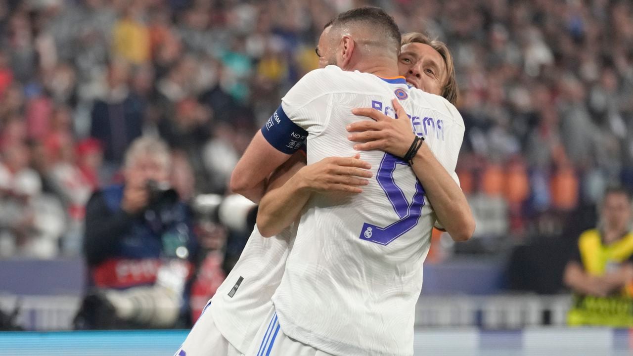 Real Madrid's Karim Benzema, foreground, and Real Madrid's Luka Modric celebrate winning the Champions League final soccer match between Liverpool and Real Madrid at the Stade de France in Saint Denis near Paris, Saturday, May 28, 2022. Real Madrid won 1-0. (AP Photo/Kirsty Wigglesworth)