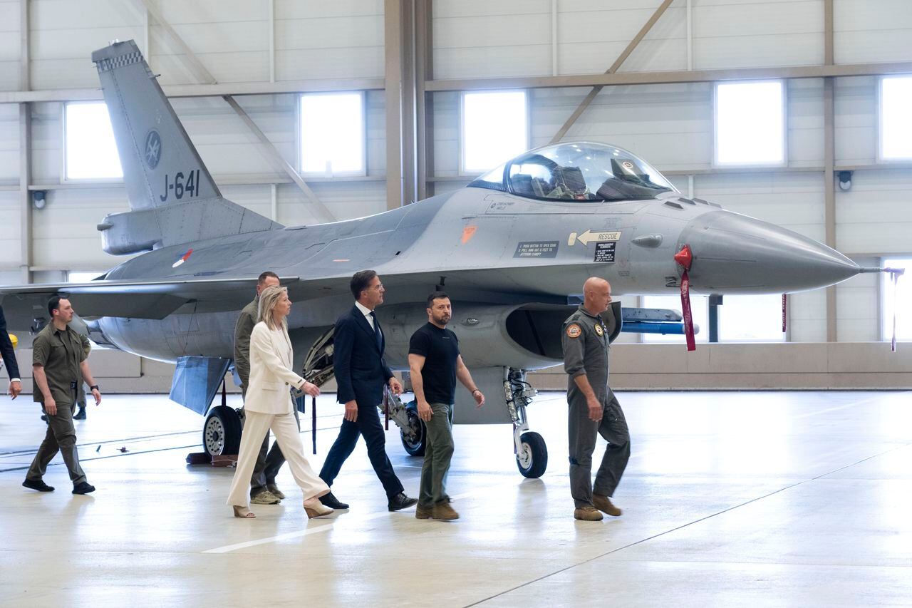 El presidente de Ucrania, Volodymyr Zelenskyy, segundo a la derecha, y el primer ministro provisional holandés, Mark Rutte, en el centro, observan aviones de combate F-16 en Eindhoven, Países Bajos, el domingo 20 de agosto de 2023. Los líderes se reunieron en una base aérea militar en el sur de Holanda.