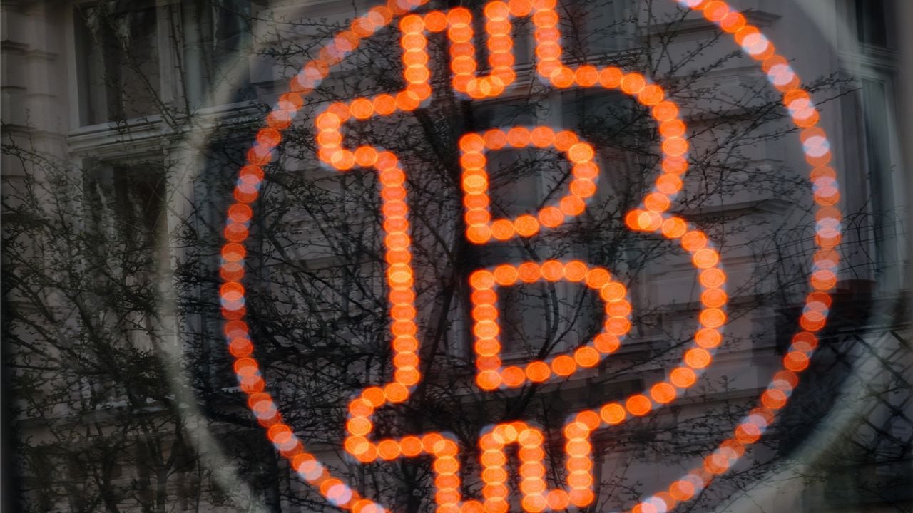 A bitcoin LED sign diplayed in a shop window offers service. Getty Images.
