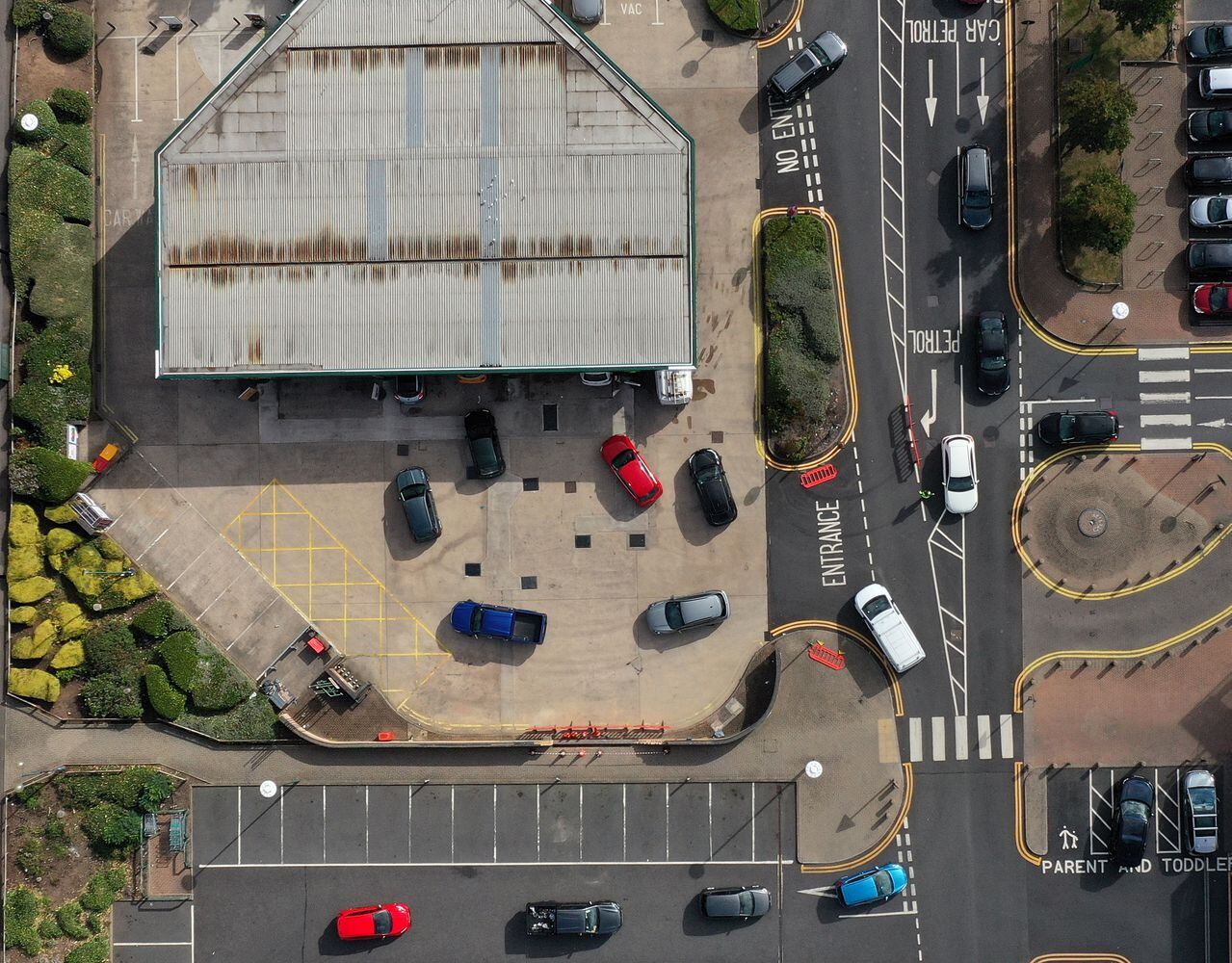 An aerial view shows motorists queueing at a petrol station in Coventry, central England on September 28, 2021. - The UK government today faced calls for nurses, police, teachers and other key workers to be given priority at petrol pumps, as the army was put on standby to ease a fuel supply crisis. (Photo by Paul ELLIS / AFP)