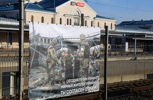 Una foto tomada por el fotógrafo ucraniano Maxim Dondiuk se ve junto a otras fotografías de la guerra de Rusia en Ucrania como parte de una exhibición en la estación de tren en Vilnius, Lituania, donde transitan los trenes desde Moscú a Kaliningrado, el 25 de marzo de 2022 (Foto de PETRAS MALUKAS / AFP)