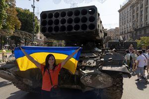 Mujer posa para una foto con una bandera nacional mientras visita una exposición de vehículos y armas militares rusos destruidos, dedicada al próximo Día de la Independencia del país, en medio del ataque de Rusia a Ucrania, en el centro de Kyiv, Ucrania, el 21 de agosto de 2022. Foto REUTERS /Valentyn Ogirenko