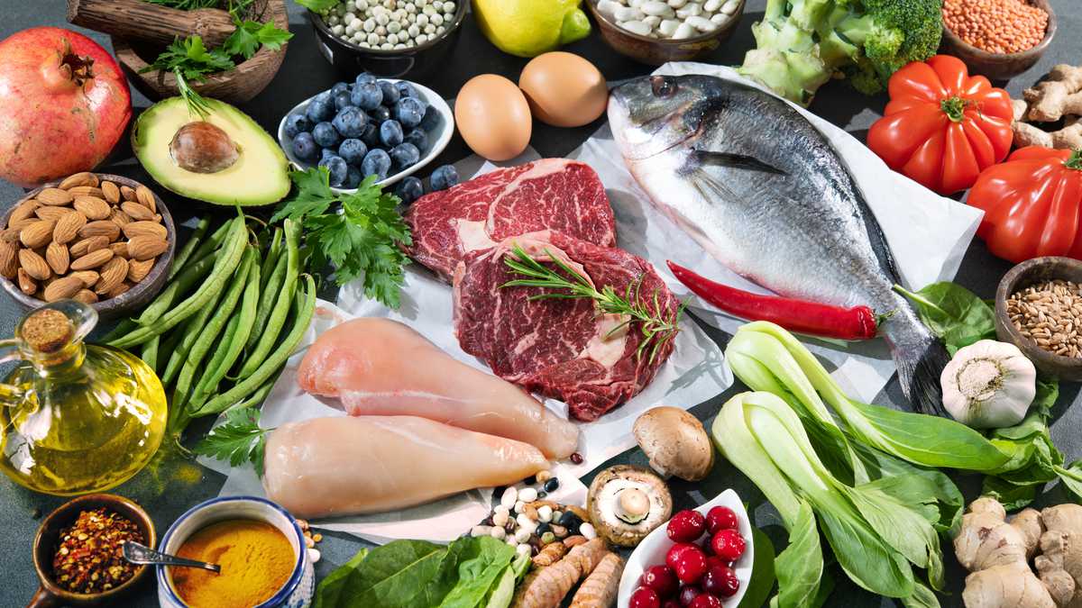 Balanced diet food background. Selection of various paleo diet products for healthy nutrition. Superfoods, meat, fish, legumes, nuts, seeds, greens and vegetables