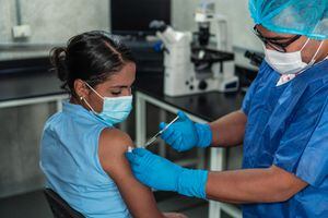 Mujer hispana recibiendo vacuna contra el coronavirus
