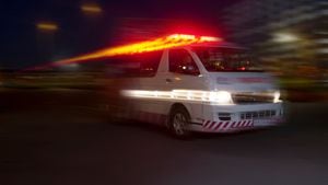 Ambulancia de emergencia a toda velocidad por la ciudad por la noche