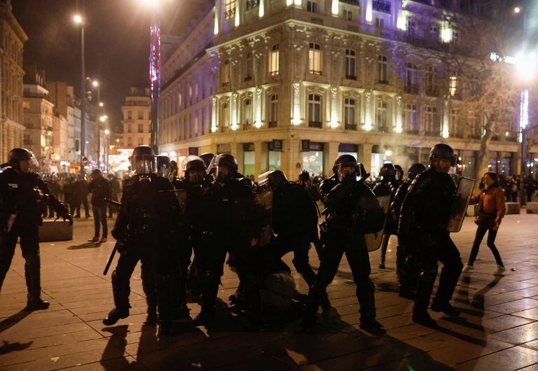 Policías con equipo antidisturbios se paran alrededor de un manifestante durante una manifestación, un día después de que se adoptara la reforma de las pensiones cuando el Parlamento francés rechazó dos mociones de censura contra el gobierno, en la Place de la Republique en París