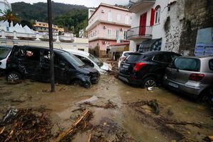 Se ven autos dañados en una carretera inundada después de que fuertes lluvias provocaran deslizamientos de tierra que colapsaron edificios y dejaron hasta 12 personas desaparecidas, en Casamicciola, en la isla de Ischia, en el sur de Italia, el sábado 26 de noviembre de 2022. Los bomberos están trabajando en los esfuerzos de rescate. ya que se envían refuerzos desde la cercana Nápoles, pero tienen dificultades para llegar a la isla en lancha o helicóptero debido al clima. (AP Photo/Salvatore Laporta)