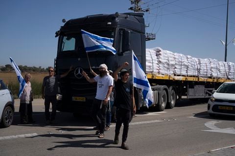 Sosteniendo banderas israelíes, personas se paran frente a camiones que transportan ayuda humanitaria mientras intentan detenerlos para ingresar a la Franja de Gaza en un área cerca del cruce fronterizo de Kerem Shalom entre Israel y Gaza, en el sur de Israel, en Kerem Shalom, el jueves 9 de mayo. , 2024.