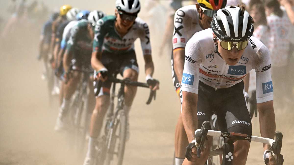 UAE Team Emirates team's Slovenian rider Tadej Pogacar wearing the best young rider's white jersey (R) cycles across a cobblestone sector with the pack of riders during the 5th stage of the 109th edition of the Tour de France cycling race, 153,7 km between Lille and Arenberg Porte du Hainaut, in northern France, on July 6, 2022. (Photo by Marco BERTORELLO / AFP)