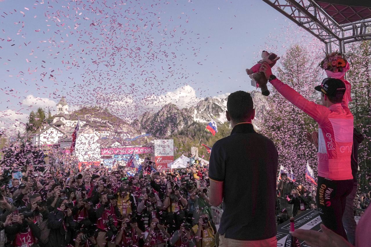 Slovenia's Primoz Roglic, right, wears the pink jersey of the overall leader as he celebrates on the podium at the end of the 20th stage of the Giro d'Italia cycling race, an individual mountain time trial from Tarvisio to Monte Lussari, Italy, Saturday, May 27, 2023. Roglic all but secured the Giro d’Italia title on Saturday by overtaking leader Geraint Thomas on the penultimate stage despite having a mechanical problem on the mountain time trial. (Marco Alpozzi/LaPresse via AP)