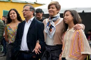 The presidential candidate with the Historical Pact, Gustavo Petro, second from left, talks to journalists upon his arrival to a poling station with his wife Veronica Alcocer, third from left, and their daughters Antonela, right and Sofia, left, to vote in presidential elections in Bogota, Colombia, Sunday, May 29, 2022. (AP Photo/Fernando Vergara)