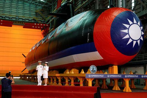 Miembros de la marina posan para fotografías junto al Narwhal, el primer submarino construido en el país, después de su ceremonia de lanzamiento en Kaohsiung, Taiwán, el 28 de septiembre de 2023.