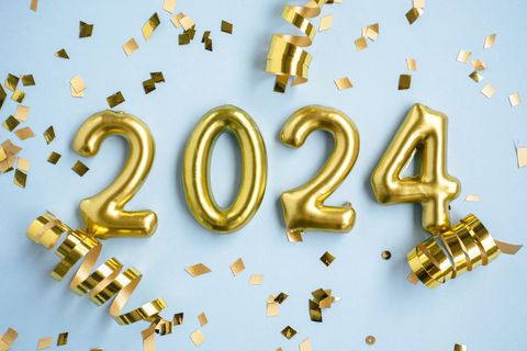 2024 New Year number. Golden digits and confetti over blue background.