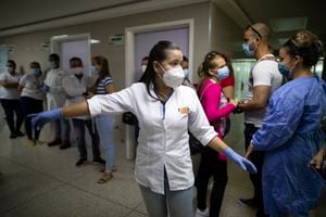 La jefa de enfermería Carla Rivero dirige a trabajadores de salud de Venezuela y Cuba, antes de que reciban una dosis de la vacuna Sinopharm COVID-19 en un centro de salud del programa de salud gubernamental Barrio Adentro, en Caracas, Venezuela. (Foto AP / Ariana Cubillos)