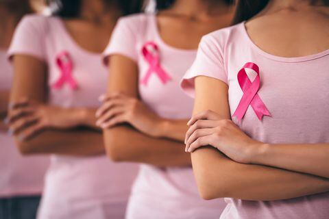 Imagen recortada del grupo de jóvenes multirraciales con cintas rosas que luchan contra el cáncer de mama. Concepto de concienciación sobre el cáncer de mama.