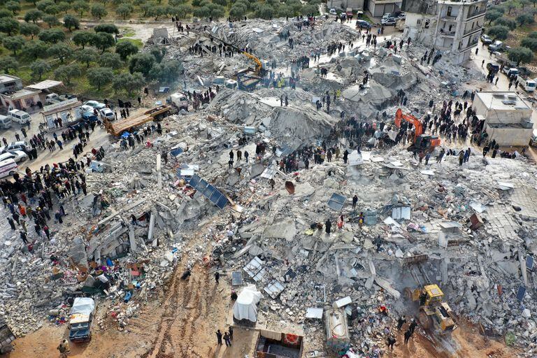 This aerial view shows residents searching for victims and survivors amidst the rubble of collapsed buildings following an earthquake in the village of Besnia near the town of Harim, in Syria's rebel-held noryhwestern Idlib province on the border with Turkey, on February 6, 2022. - Hundreds have been reportedly killed in north Syria after a 7.8-magnitude earthquake that originated in Turkey and was felt across neighbouring countries. (Photo by Omar HAJ KADOUR / AFP)