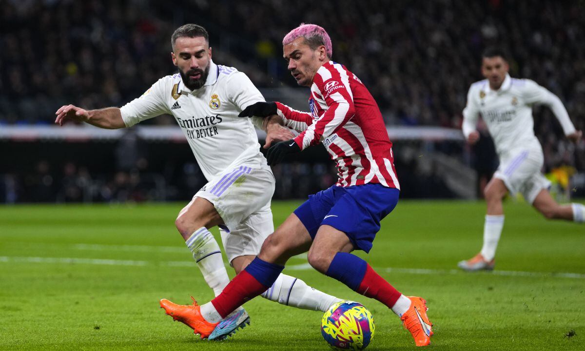 Atletico Madrid's Antoine Griezmann, right, fights for the ball with Real Madrid's Dani Carvajal during a Spanish La Liga soccer match between Real Madrid and Atletico Madrid at the Santiago Bernabeu stadium in Madrid, Spain, Saturday, Feb. 25, 2023. (AP/Manu Fernandez)