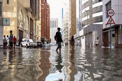 Personas caminan entre las inundaciones provocadas por las fuertes lluvias, en Dubái, Emiratos Árabes Unidos, el 17 de abril de 2024.