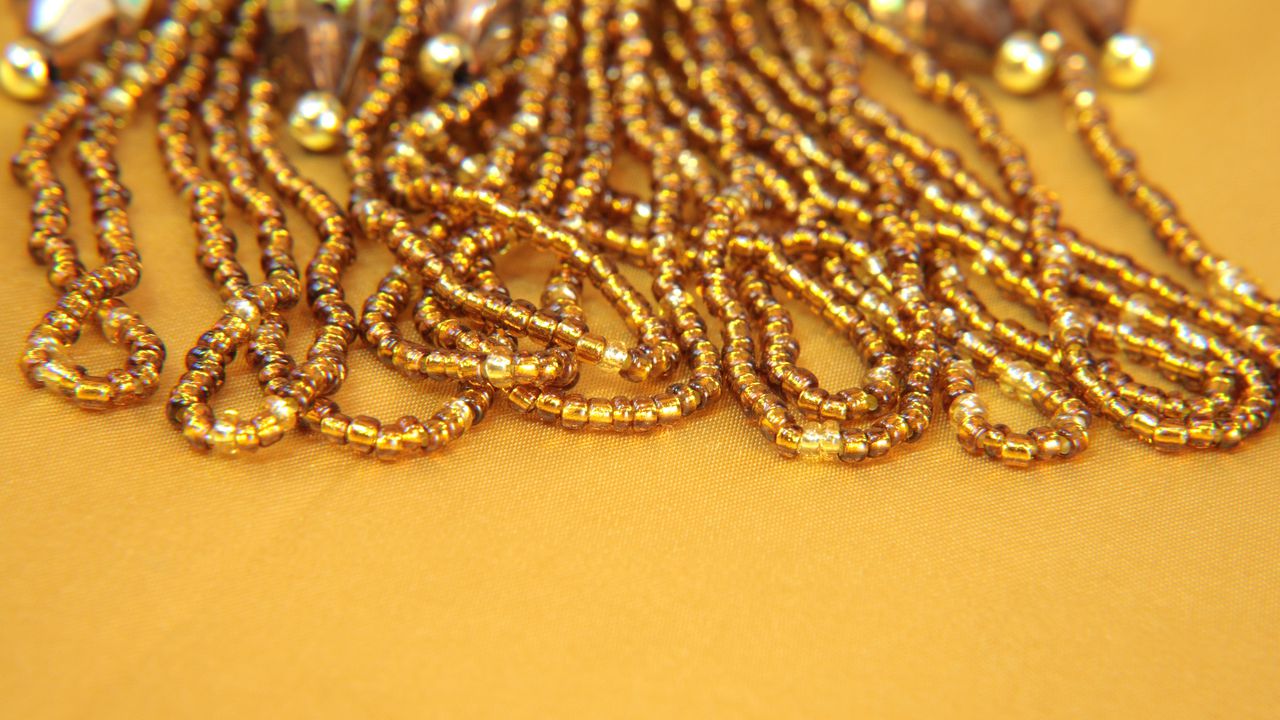 Gold iridescent beads and sequins on a gold background.