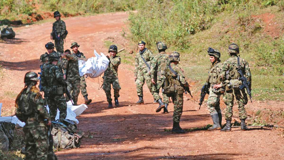 SIN EXPLICACIONES - El ataque sorpresivo en Cauca dejó en entredicho el cese del fuego declarado por las Farc en diciembre. Soldados sacan los cuerpos destrozados de sus 11 compañeros el miércoles pasado.  