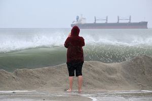 Un visitante de la playa observa las olas desde la costa en Long Beach, California, el 20 de agosto de 2023.  (Photo by Robyn Beck / AFP)