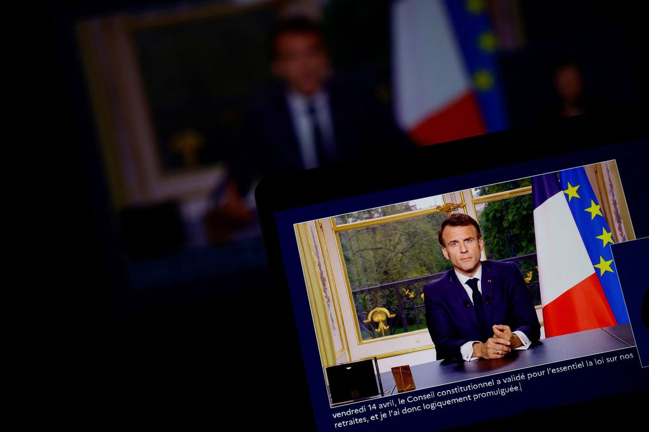 El presidente francés, Emmanuel Macron, aparece en una pantalla, mientras habla durante un discurso especial a la nación desde el Palacio del Elíseo, después de promulgar la reforma de las pensiones que eleva la edad de jubilación, en París