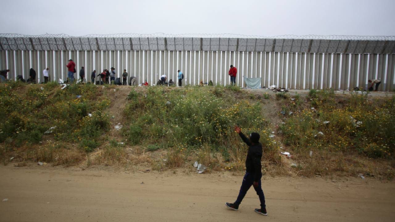 Migrantes acampan entre las dos vallas fronterizas. Visto desde Tijuana (México).