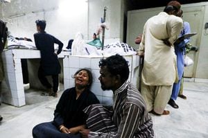 La gente llora la muerte de un pariente, que fue asesinado junto con otros en una estampida durante la distribución de folletos y comida en la morgue de un hospital en Karachi, Pakistán