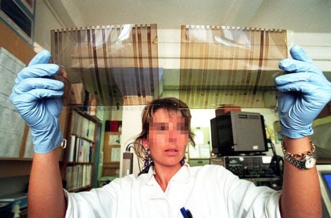 Mujer sostiene los resultados de una prueba de ADN en un laboratorio. Imagen de referencia