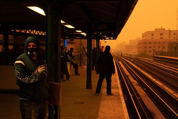 Una persona que espera el metro usa una máscara filtrada mientras la neblina humeante de los incendios forestales en Canadá cubre un vecindario el 7 de junio de 2023 en el distrito del Bronx de la ciudad de Nueva York. Nueva York encabezó la lista de las principales ciudades más contaminadas del mundo el martes por la noche, mientras el humo de los incendios continúa cubriendo la costa este. (Foto de David Dee Delgado/Getty Images)
