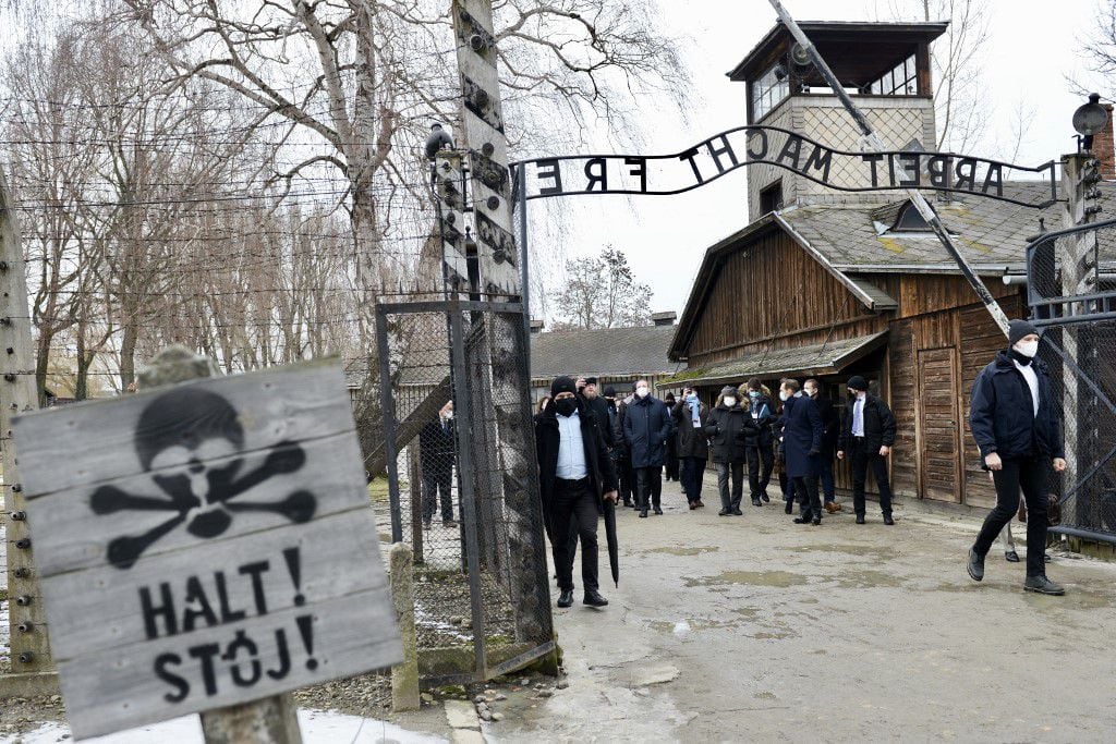 El primer ministro francés, Jean Castex (C), se encuentra en la puerta durante una visita al Memorial y Museo Auschwitz-Birkenau del antiguo campo de concentración y exterminio nazi alemán en Oswiecim, Polonia, el 27 de enero de 2022, en el 77.° aniversario de la liberación de Auschwitz, en conmemoración del Día Internacional de Conmemoración del Holocausto.
