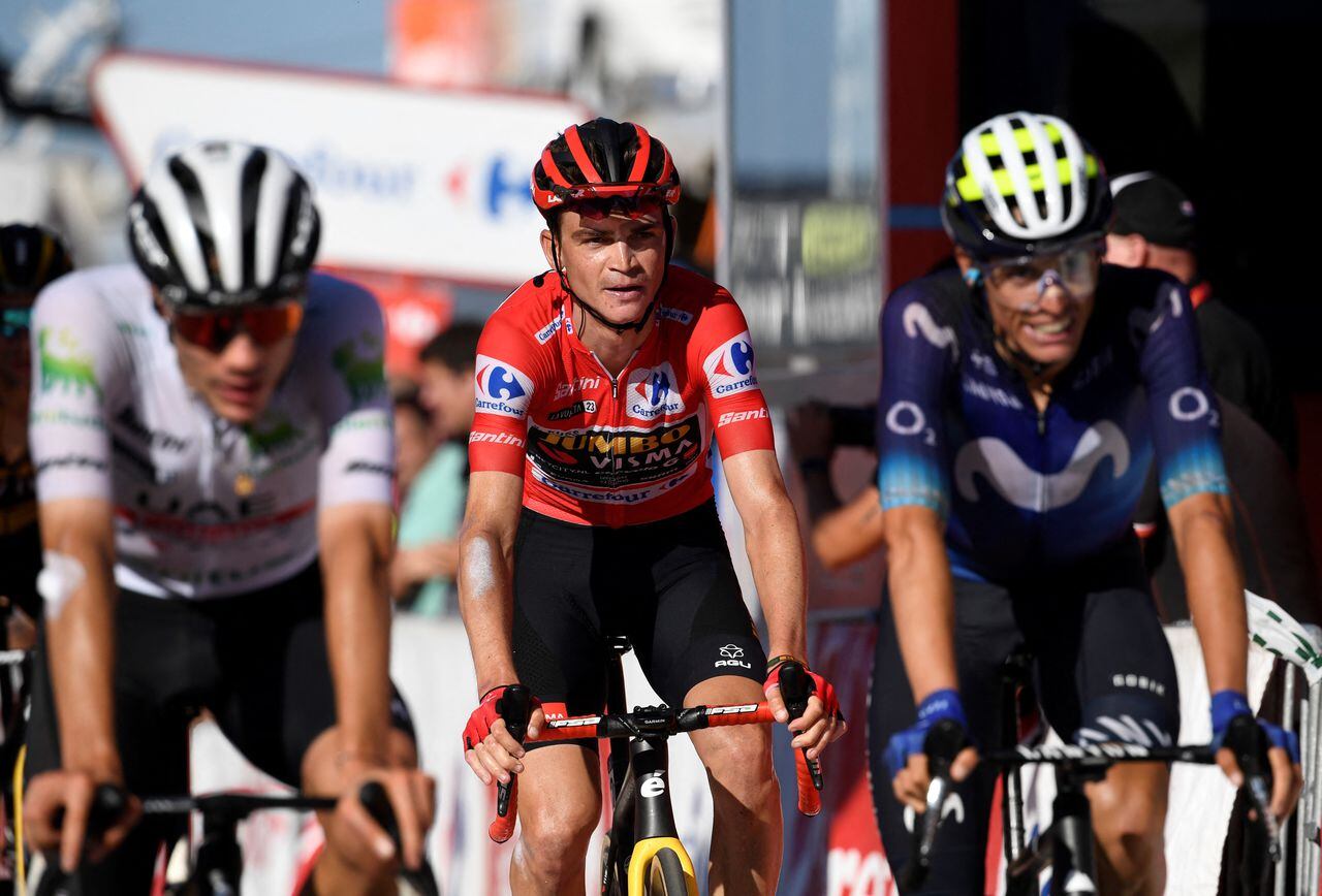 Team Jumbo-Visma's US rider Sepp Kuss (C) wearing the overall leader's red jersey crosses  the finish line of the stage 18 of the 2023 La Vuelta cycling tour of Spain, a 178,9 km race between Pola de Allande and Puerto de La Cruz de Linares on September 14, 2023. (Photo by MIGUEL RIOPA / AFP)
