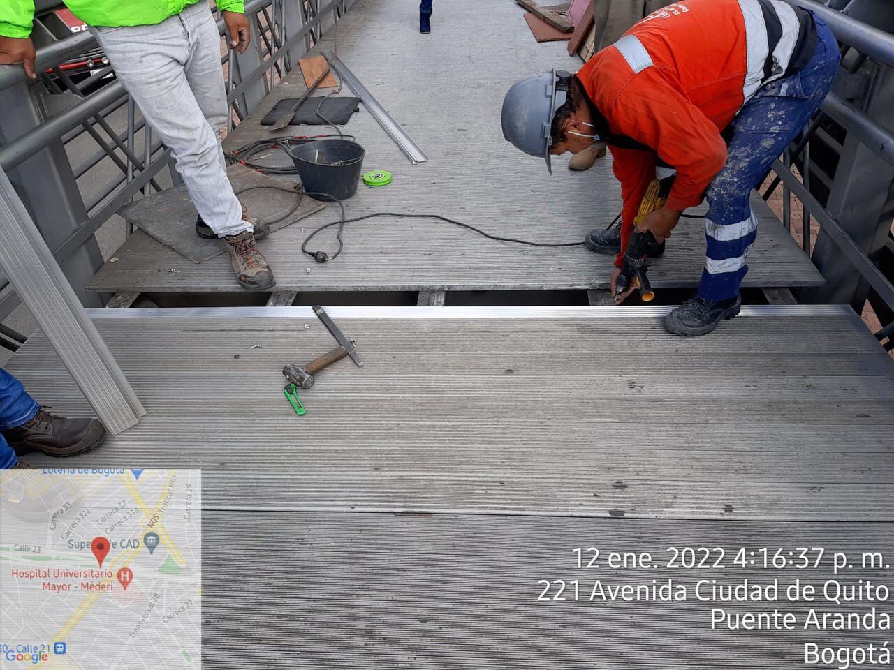 Funcionarios del IDU reparando el puente peatonal que da acceso a la Clínica Méderi.