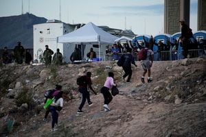 Migrantes que buscan asilo celebran después de cruzar el Río Bravo hacia El Paso, Texas, EE. UU., visto desde Ciudad Juárez, México, el 3 de octubre de 2022.