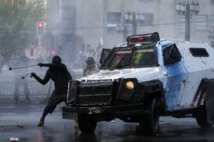 Un manifestante golpea un vehículo policial blindado durante una manifestación en el tercer aniversario de las protestas y disturbios que sacudieron el país en 2019, en Santiago, Chile, 18 de octubre de 2022.