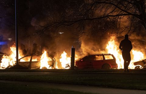 Varios vehículos son arrasados por las llamas tras el estallido de protestas en Rosengard, distrito de Malmö, Suecia, la noche del domingo 17 de abril de 2022.