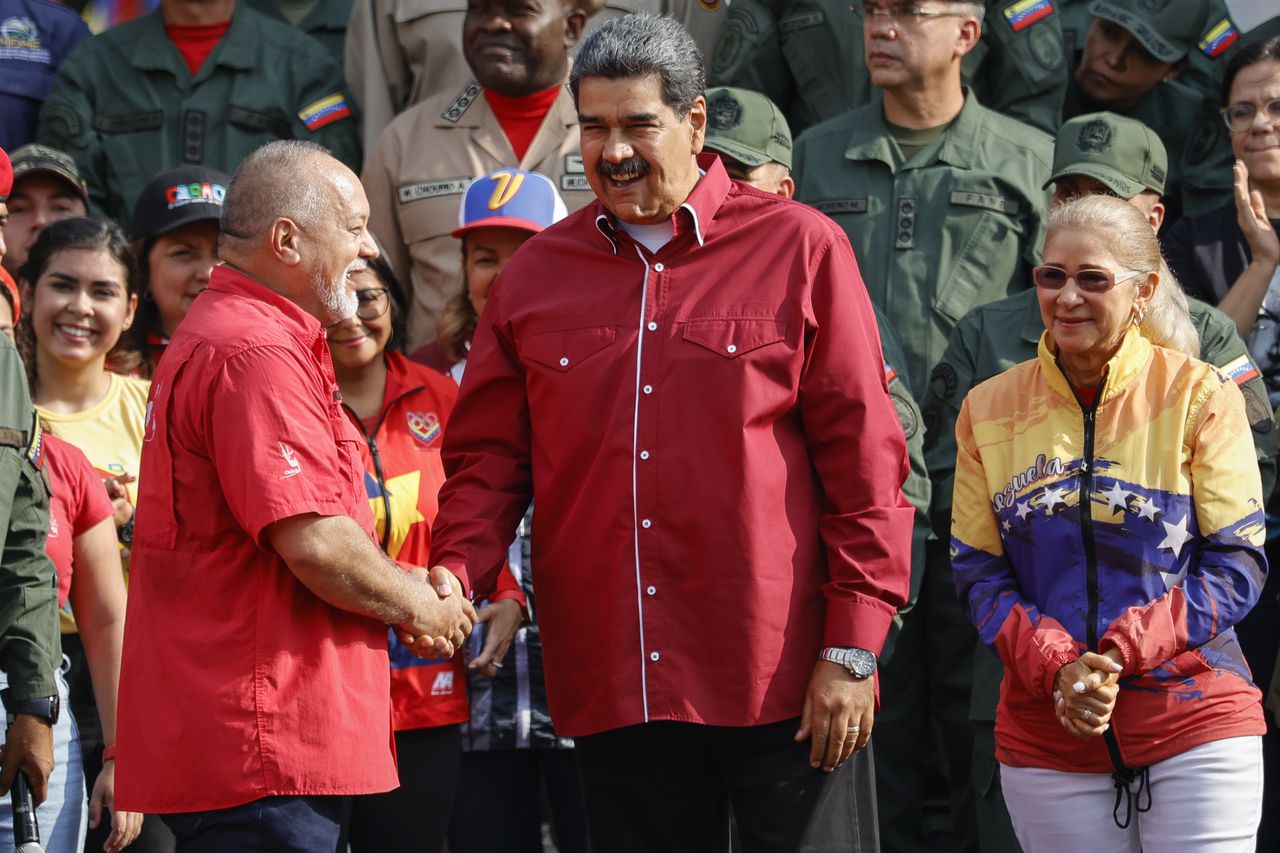 El presidente Nicolás Maduro, en el centro, le da la mano al legislador Diosdado Cabello, quien también es vicepresidente del gobernante Partido Socialista Unido de Venezuela