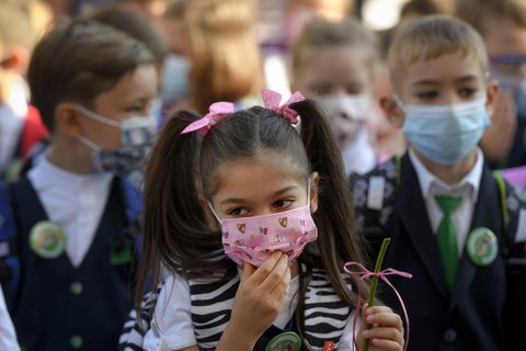 Una niña se acomoda la mascarilla durante las festividades que marcan el comienzo del año escolar. (Foto AP / Andreea Alexandru)
