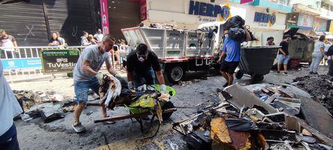 Comerciantes del centro de Cali rescatan lo que pueden del centro comercial el tesoro luego del incendio que consumió a este establecimiento.