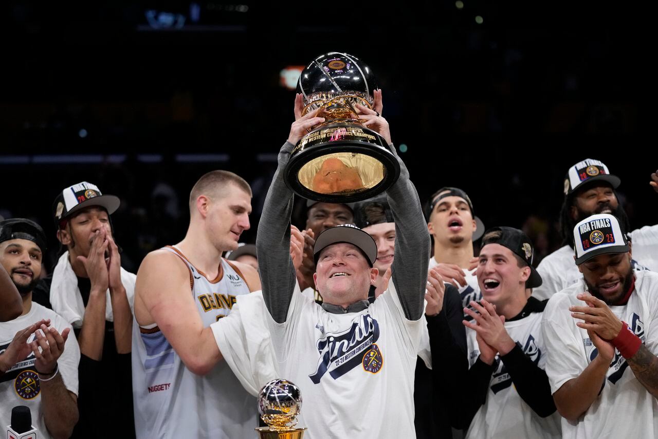 El entrenador de los Nuggets de Denver sostiene el trofeo de campeón de conferencia tras vencer en el juego 4 de las finales de la Conferencia Oeste
