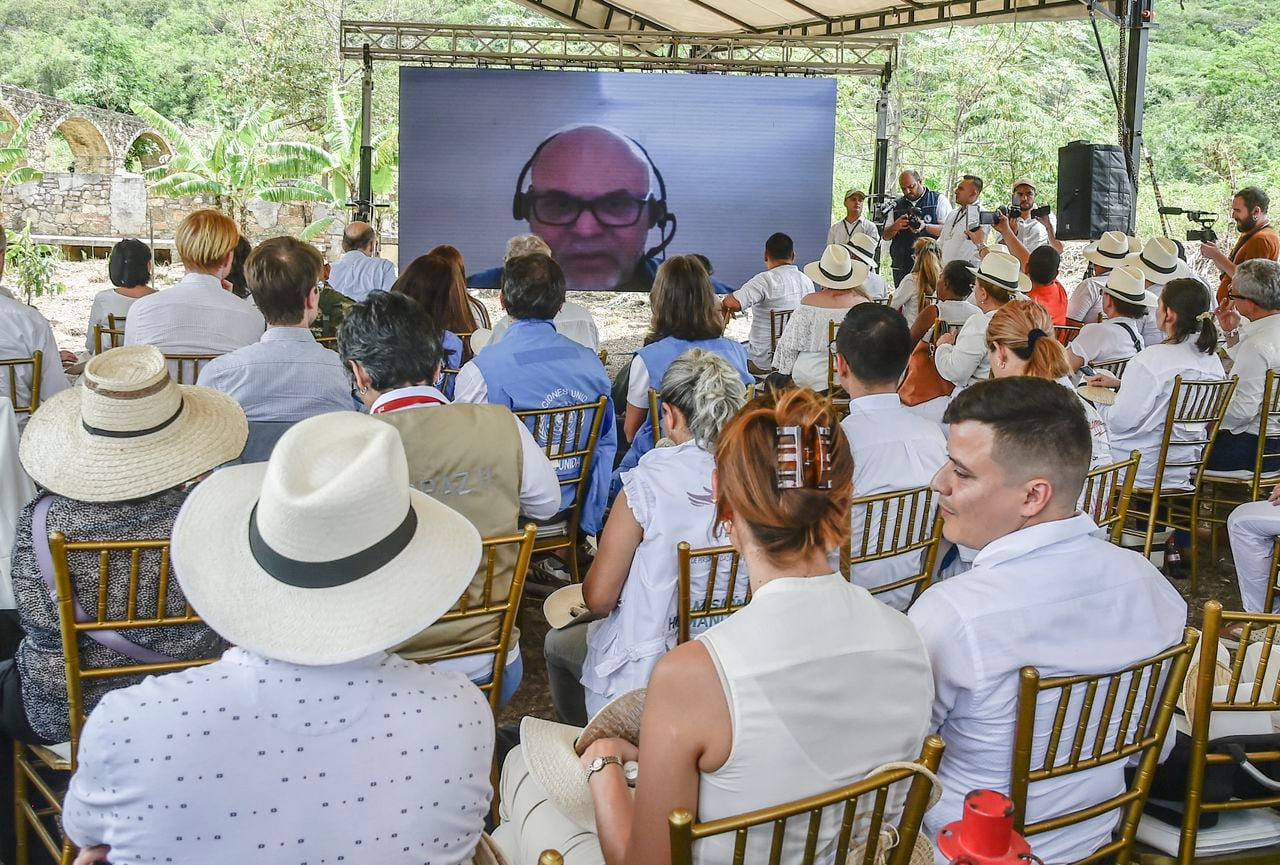 La gente mira una pantalla con la imagen de Salvatore Mancuso, excomandante las AUC durante una ceremonia en una cámara crematoria donde los grupos paramilitares desaparecieron a sus víctimas durante el conflicto armado, en el sector de Juan Frio en el municipio de Villa del Rosario, Colombia el 9 de mayo de 2023.