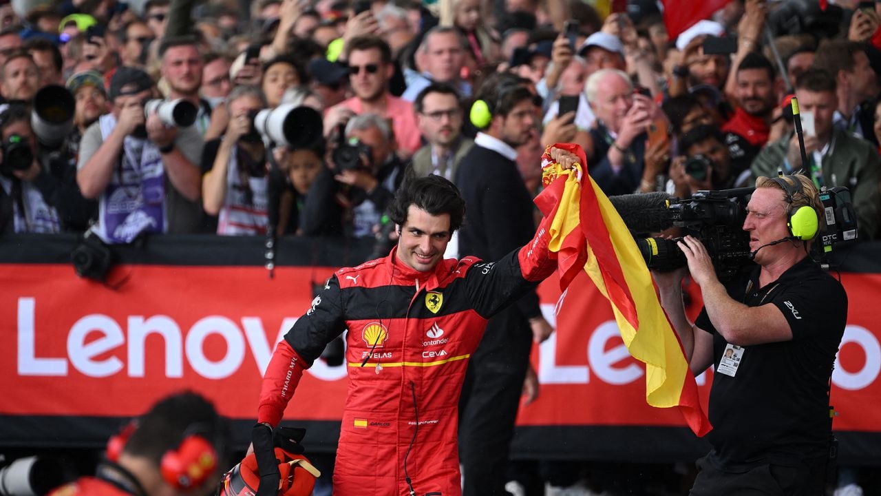 Race winner Ferrari's Spanish driver Carlos Sainz Jr waves a Spanish flag after winning the Formula One British Grand Prix at the Silverstone motor racing circuit in Silverstone, central England on July 3, 2022. (Photo by JUSTIN TALLIS / AFP)