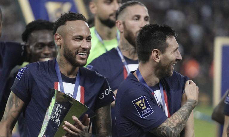 PSG's Neymar, left, holds the trophy as he celebrate with his teammate Lionel Messi after winning the French Super Cup final soccer match between Nantes and Paris Saint-Germain at Bloomfield Stadium in Tel Aviv, Israel, Sunday, July 31, 2022. PSG won 4-0. (AP/Ariel Schalit)