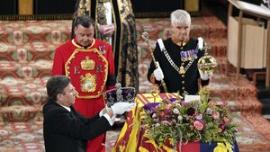 El Joyero de la Corona, a la izquierda, retira la Corona del Estado Imperial del ataúd de la Reina Isabel II de Gran Bretaña durante un servicio de compromiso en la Capilla de San Jorge, en el Castillo de Windsor, en Windsor, Inglaterra, el lunes 19 de septiembre de 2022