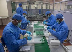 Los empleados empacan cajas que contienen viales de Covishield, una versión de la vacuna AstraZeneca, en el Serum Institute of India (AP Photo/Rafiq Maqbool, File)